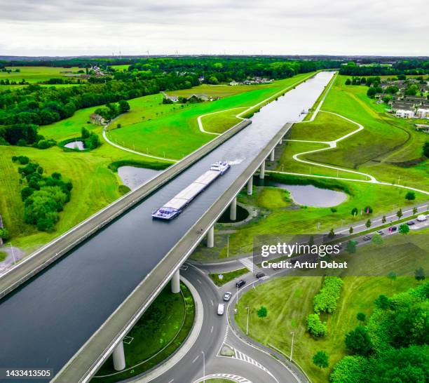 aerial view of the sart canal bridge crossing road in the green landscape of belgium. - energy solutions stock pictures, royalty-free photos & images