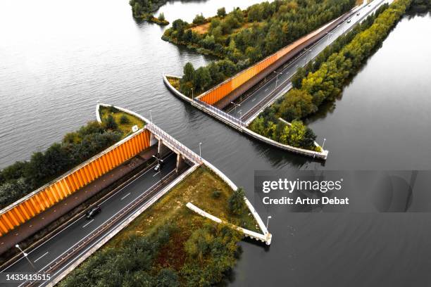 aerial view of the veluwemeer aqueduct with complexity engineering crossing above highway in the netherlands. - veluwemeer bildbanksfoton och bilder