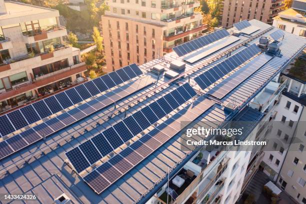 solar panels on the roof of an apartment building - apartment exterior stock pictures, royalty-free photos & images