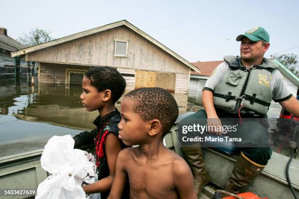 Mark Benton , of Louisiana Department of Wildlife and Fisheries, helps to rescue young family members after they were trapped on a school rooftop...