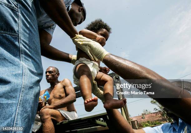 Young child is lifted onto a truck after being rescued and brought ashore in a boat after Hurricane Katrina August 30, 2005 in New Orleans,...