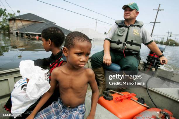 Mark Benton , of Louisiana Department of Wildlife and Fisheries, helps to rescue young family members after they were trapped on a school rooftop...