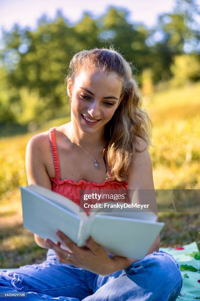 Young Woman In Jeans And Top Outdoors Sitting In The Park On A Picnic ...