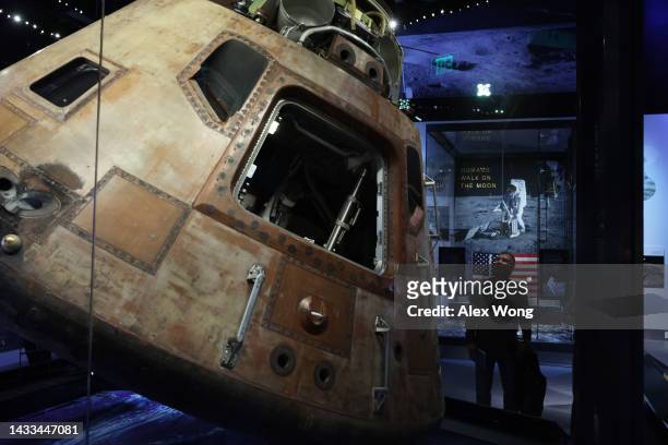 Visitor looks at Columbia, the Apollo 11 Command Module, at the “Destination Moon” exhibit at The Smithsonian National Air and Space Museum on its...