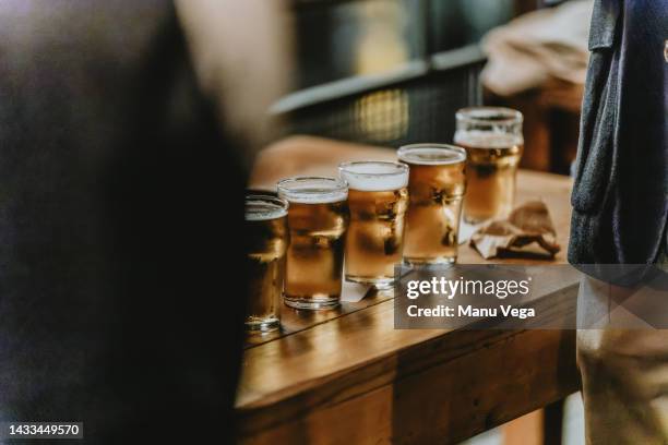a row of glasses with beer on a table - binge drinking 個照片及圖片檔