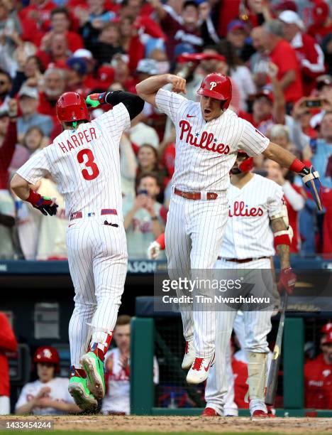 Bryce Harper of the Philadelphia Phillies celebrates with teammate J.T. Realmuto after hitting a two run home run against the Atlanta Braves in game...