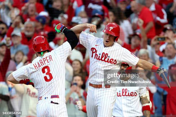 Bryce Harper of the Philadelphia Phillies celebrates with teammate J.T. Realmuto after hitting a two run home run against the Atlanta Braves during...