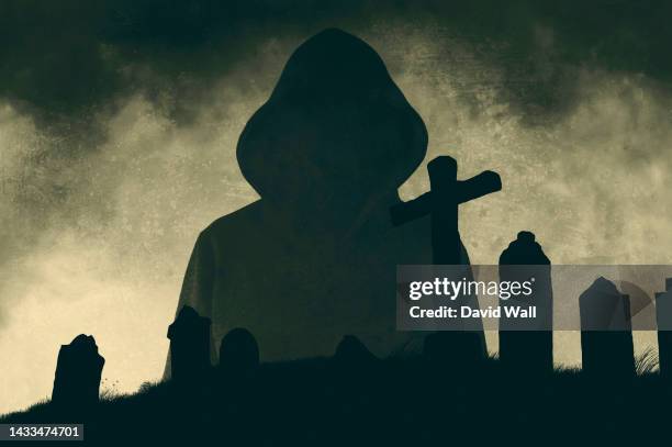 a horror concept of a hooded spooky ghost. silhouetted against a graveyard. on a stormy night. - grim reaper stock pictures, royalty-free photos & images