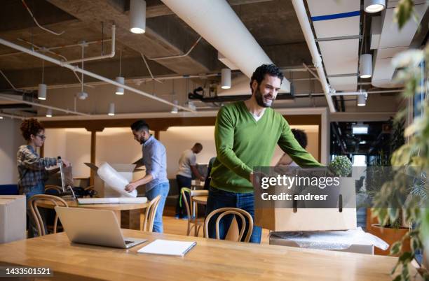 workers moving into a new office and packing their belongings - mudança de escritório imagens e fotografias de stock