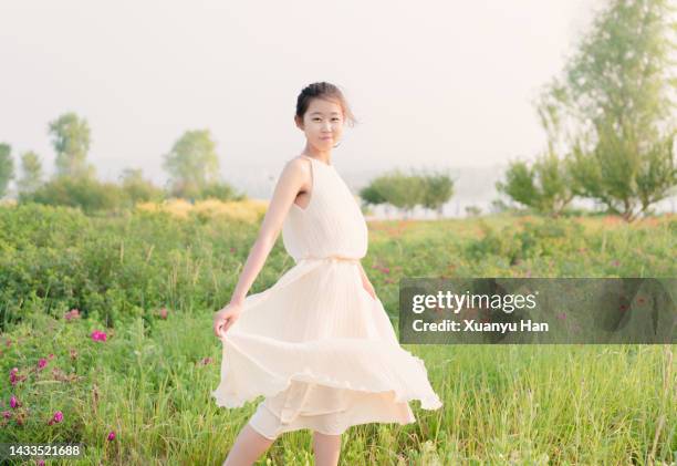 young woman in a white skirt on the grass - woman sleeveless dress stock pictures, royalty-free photos & images