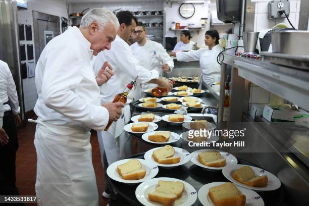 Alain Ducasse touches up baba au rhum at a dinner hosted by Alain Ducasse and Alberto Marcolongo during the 2022 New York City Wine & Food Festival...