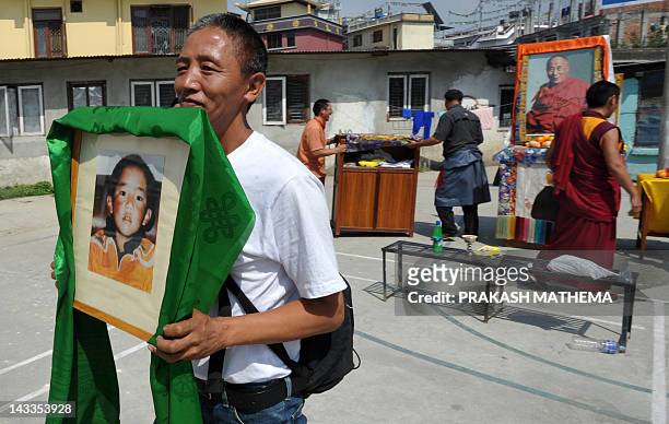 Tibetan man holds a portrait of Tibetan spiritual leader the Panchen Lama after celebrating his 23rd birth anniversary at the Tibetan Welfare Centre,...