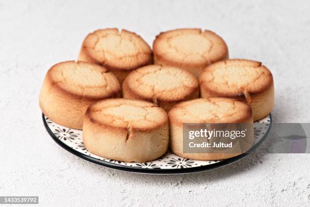 christmas shortbread in a decorated earthenware dish, on a white textured base. - polvorón stock pictures, royalty-free photos & images