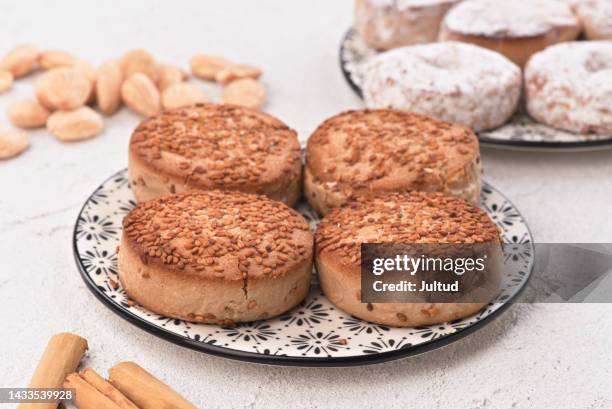 christmas shortbread in a decorated earthenware dish, on a white textured base. - polvorón stock pictures, royalty-free photos & images