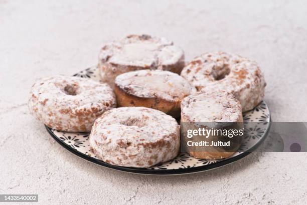 christmas shortbread and rosquillas sprinkled on decorated plate on white textured base - rosquillas ストックフォトと画像
