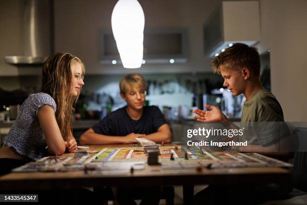 adolescenti che giocano a grandi giochi da tavolo insieme a casa - game night foto e immagini stock