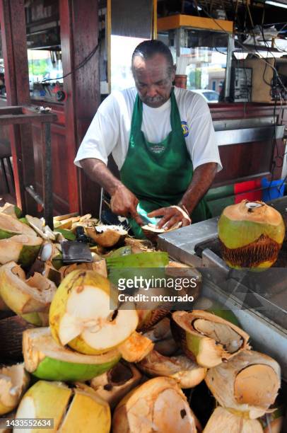 mann schneidet kokosnüsse, marigot, französisch saint martin - saint martin caraibi stock-fotos und bilder