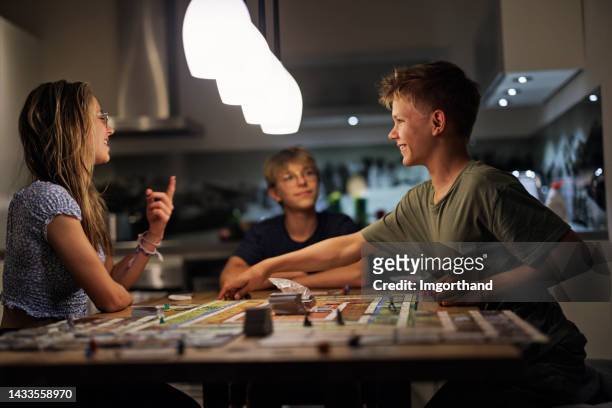 teenagers playing large board game together at home - family game night stock pictures, royalty-free photos & images
