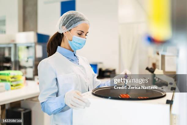 young woman in a laboratory for medicine ,holding test tube using centrifuge - reageerbuisrek stockfoto's en -beelden