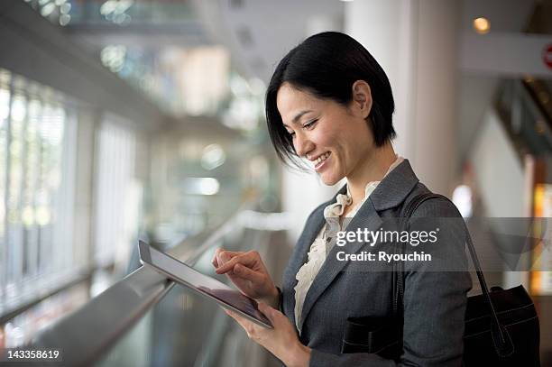 businesswoman you are using a tablet - one mature woman only ストックフォトと画像