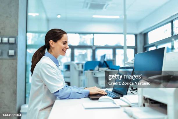 smiling young woman in a laboratory for medicine, innovation and development while reading or analyzing data - medical dictionary stock pictures, royalty-free photos & images