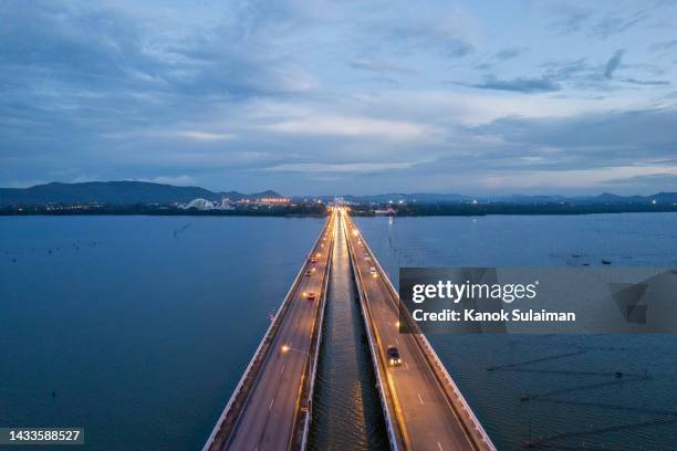 aerial image directly above a highway crossing over lake in songkhla province, thailand at sunset - rise above it stock pictures, royalty-free photos & images