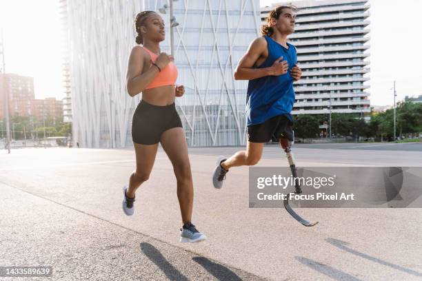 young couple jogging in the city - disabled runner stock pictures, royalty-free photos & images