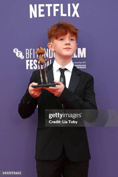 Gregory Mann poses with a small replica of Pinocchio during the "Guillermo Del Toro's Pinocchio" world premiere during the 66th BFI London Film...