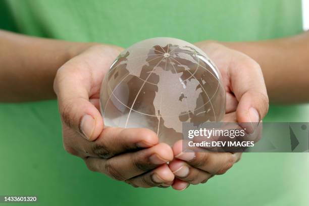 closeup of glass globe in woman hands - frau globus stock-fotos und bilder