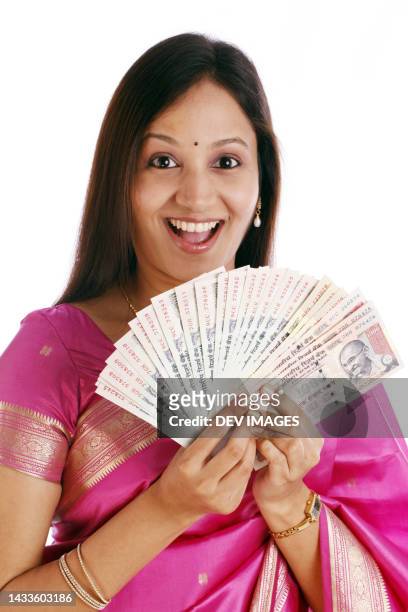 excited traditional woman holding indian currency - indian currency stock-fotos und bilder