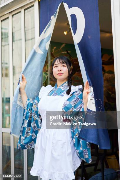 woman in kimono and apron looking out through the curtain - noren stock pictures, royalty-free photos & images