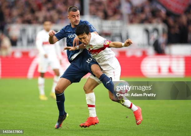 Wataru Endo of VfB Stuttgart is challenged by Philipp Foerster of VfL Bochum during the Bundesliga match between VfB Stuttgart and VfL Bochum 1848 at...