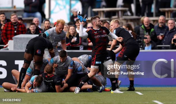 Elliot Daly of Saracens pulls off the scrum cap of Richard de Carpentier of Bath and throws it into the crowd during the Gallagher Premiership Rugby...