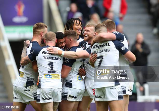 Kallum Watkins of England celebrates with teammates after scoring their side's fourth try during the Rugby League World Cup 2021 Pool A match between...