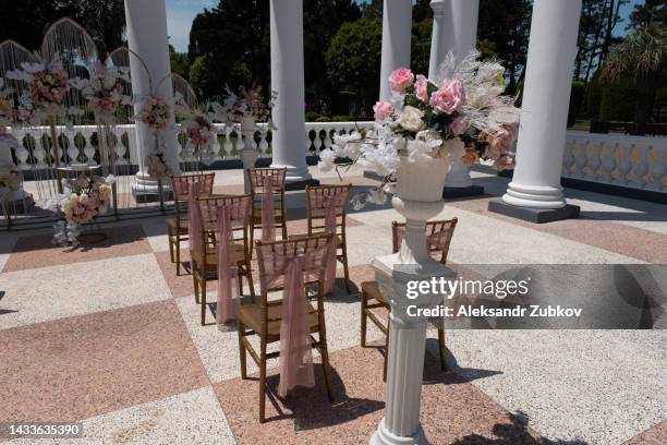 chairs for a wedding reception decorated with fabric or a veil. wedding ceremony in the open air, bouquets of flowers. beautiful decoration and decoration, wedding decor. - open seat godo stock-fotos und bilder