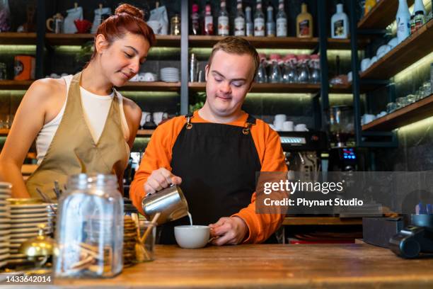 joven con síndrome de down trabajando en un café, preparando café - dedicación fotografías e imágenes de stock