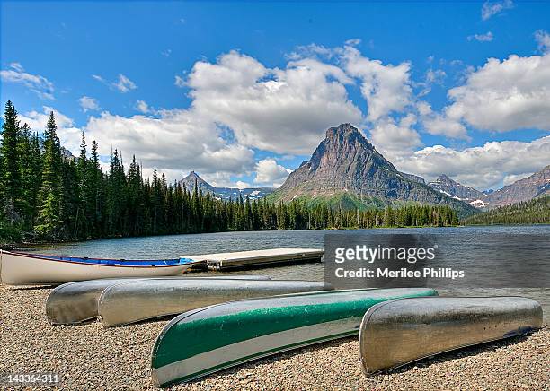 canoes waiting along shore of two medicine lak - lago two medicine montana - fotografias e filmes do acervo