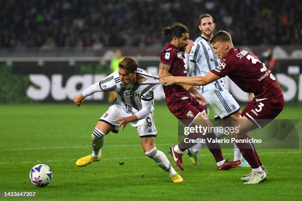 Dusan Vlahovic of Juventus is challenged by Perr Schuurs of Torino FC during the Serie A match between Torino FC and Juventus at Stadio Olimpico di...