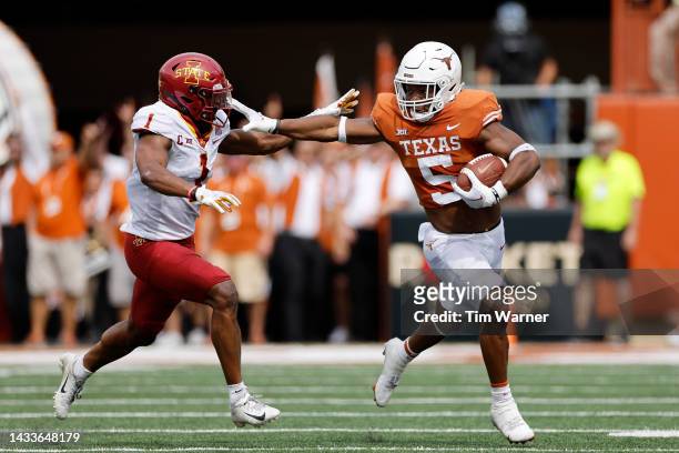 Bijan Robinson of the Texas Longhorns gives a stiff arm to Anthony Johnson Jr. #1 of the Iowa State Cyclones in the second quarter at Darrell K...