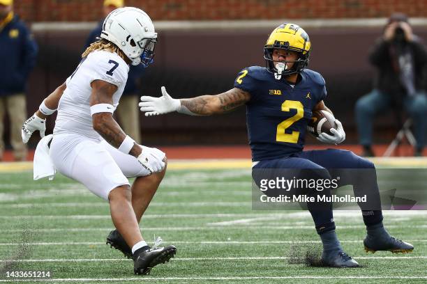 Blake Corum of the Michigan Wolverines looks to avoid a tackle by Jaylen Reed of the Penn State Nittany Lions in the first half of a game at Michigan...