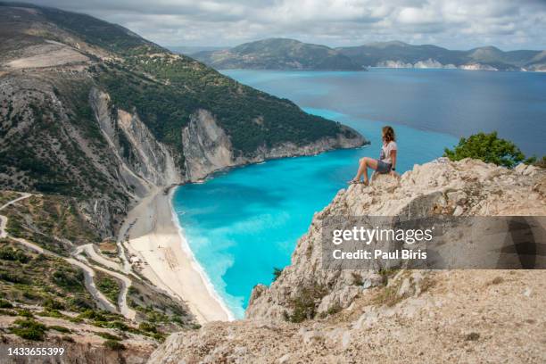 woman  with an exciting feeling of freedom, looking at myrtos beach. cephalonia island, greece - paul of greece - fotografias e filmes do acervo