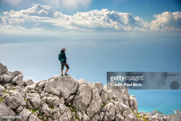 beautiful fit young woman hiking up a mountain and enjoying at the view on the island of  kefalonia - pioneer stock pictures, royalty-free photos & images