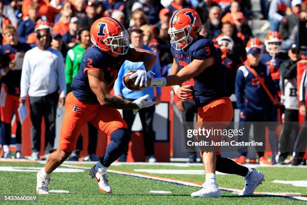 Tommy DeVito of the Illinois Fighting Illini hands the ball off to Chase Brown during the first half in the game against the Minnesota Golden Gophers...