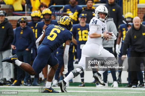 Sean Clifford of the Penn State Nittany Lions tries to avoid a tackle by R.J. Moten of the Michigan Wolverines at Michigan Stadium on October 15,...