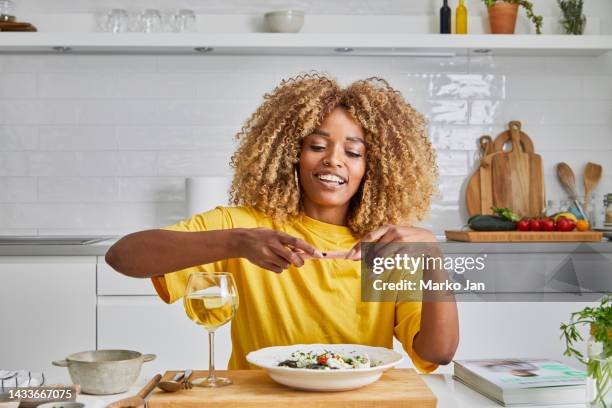 beautiful girl taking a picture of a plate - single adults eating dinner at home stock pictures, royalty-free photos & images