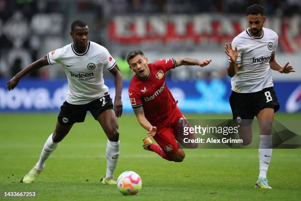Charles Aranguiz of Leverkusen is challenged by Evan N'Dicka and Djibril Sow of Eintracht Frankfurt during the Bundesliga match between Eintracht...