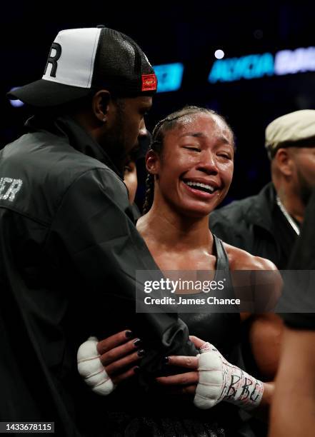 Alycia Baumgardner celebrates with trainers after victory in the IBF, IBO, WBC and WBO Super Featherweight World Title fight between Mikaela Mayer...