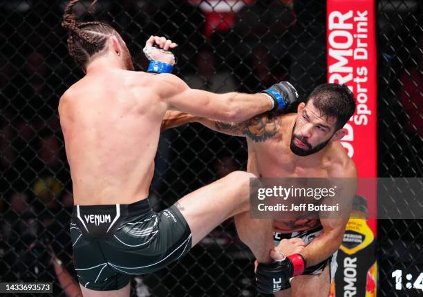 Raphael Assuncao of Brazil punches Victor Henry in a bantamweight fight during the UFC Fight Night event at UFC APEX on October 15, 2022 in Las...