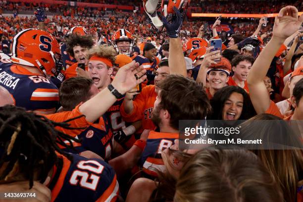 Syracuse Orange fans and players celebrate after a game against the North Carolina State Wolfpack at JMA Wireless Dome on October 15, 2022 in...