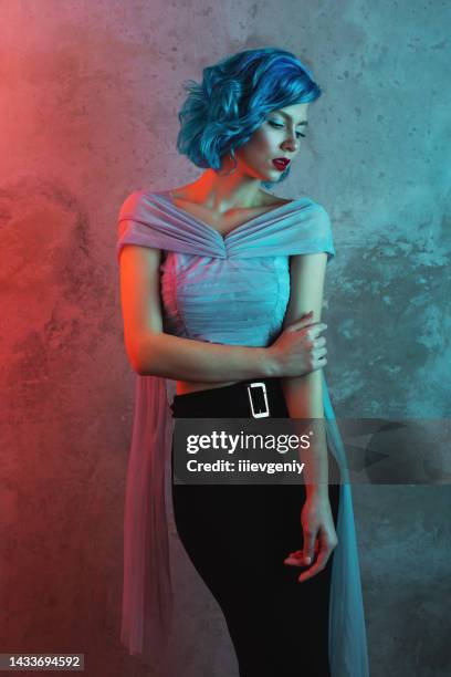 fille aux cheveux bleus dans le studio sur fond de mur. modèle avec maquillage de beauté. portrait. lèvres rouges. génération z - cheveux fluo photos et images de collection